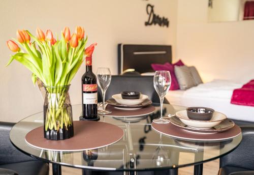a table with a vase of flowers and a bottle of wine at TRUTH - Winternest - Smart TV - Terrasse - Kamin in Brilon