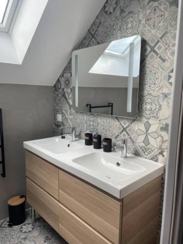 W łazience znajduje się umywalka i lustro. w obiekcie Les Bulles Blanches w mieście Avize