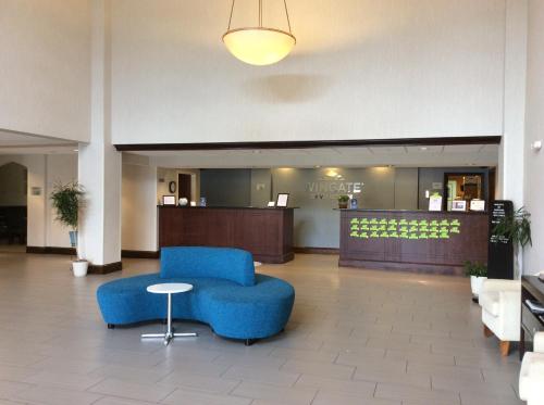 a lobby with a blue chair and a table at Wingate by Wyndham High Point Greensboro in High Point