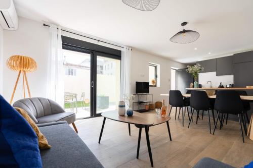 un salon avec un canapé et une table dans l'établissement La Maison du Parc I Standing 3 chambres 8 pers Parking Clim Wifi Vélodrome, à Marseille