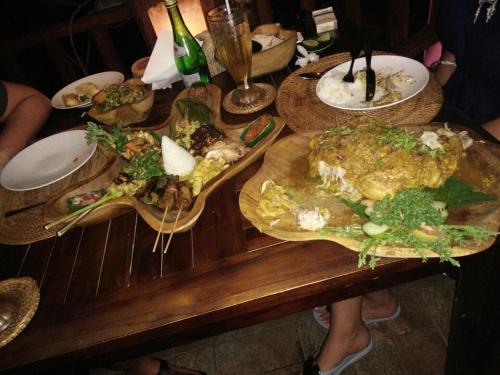 a wooden table with plates of food on it at Villa Mola Mola in Candidasa