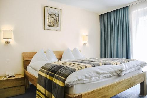 a bedroom with a large bed with a window at Hotel Regina Terme in Leukerbad