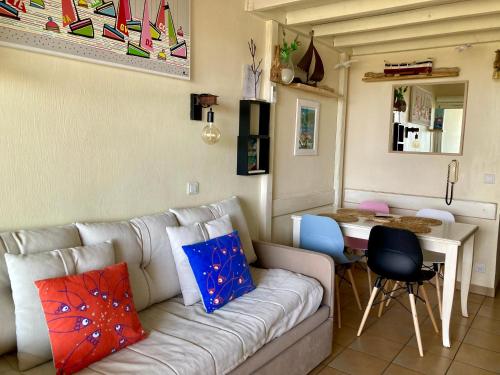 a living room with a couch and a table at Les Restanques coquelicot vue mer in Grimaud