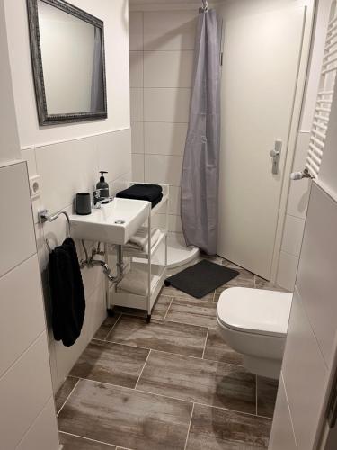 een badkamer met een wastafel en een toilet bij gemütliche Monteurwohnung,Ferienwohnung in Nörten-Hardenberg