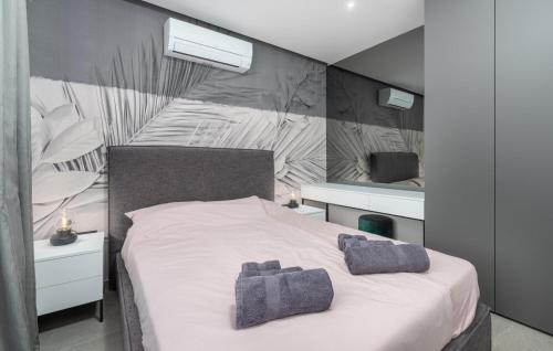 Un dormitorio con una cama blanca con dos toallas encima. en Villa Athos, en Karigador