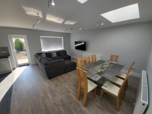 a living room with a dining table and a couch at High Spec Large 6 Bedroom House! in Kingston upon Thames