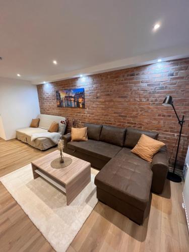 a living room with a couch and a brick wall at gemütliche Monteurwohnung,Ferienwohnung in Nörten-Hardenberg