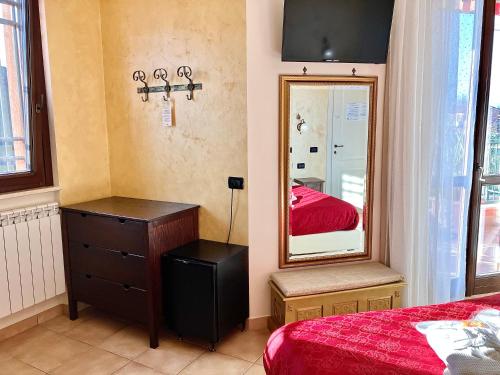 a bedroom with a bed and a dresser and a mirror at B&B Desenzano Paradise in Desenzano del Garda