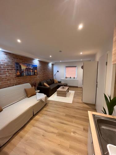 a living room with a couch and a brick wall at gemütliche Monteurwohnung,Ferienwohnung in Nörten-Hardenberg