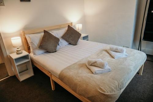 - une chambre avec un lit et des serviettes dans l'établissement 63 Westmorland St by Prestige Properties SA, à Barrow-in-Furness
