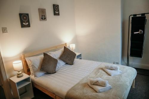 - une chambre avec un lit et des serviettes dans l'établissement 63 Westmorland St by Prestige Properties SA, à Barrow-in-Furness