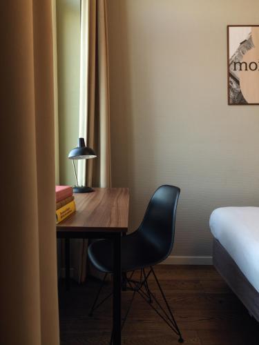 a desk in a room with a chair and a bed at Townhouse Maastricht & Spa in Maastricht