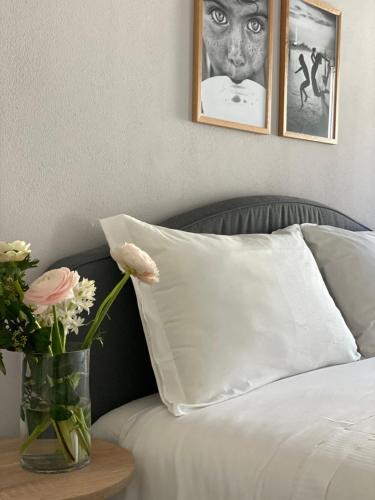 a vase of flowers on a table next to a bed at Casimiro Home in Cesena