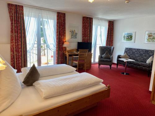 um quarto de hotel com uma cama, uma secretária e cadeiras em Seehotel Schäpfle em Überlingen