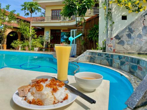 een bord eten en drinken op een tafel naast een zwembad bij Mom's homestay in Ninh Binh