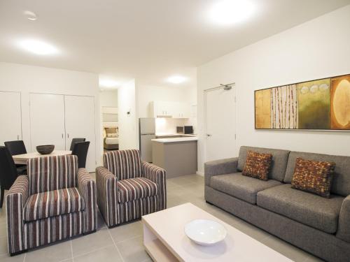 een woonkamer met een bank, stoelen en een tafel bij Oaks Middlemount Suites in Middlemount