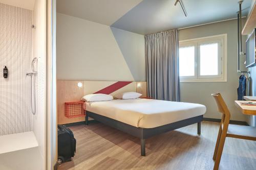 a hotel room with a bed and a bathroom at ibis budget Paris Porte d'Aubervilliers in Aubervilliers