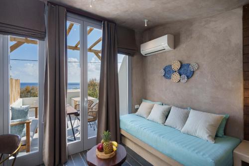 a living room with a blue couch and a balcony at Elixir Del Mar on the Beach in Kamari