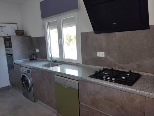 a kitchen with a stove top oven next to a sink at Casa rural Fuente Americana in Moratalla