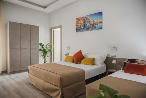 a bedroom with two beds and a painting on the wall at Nido Suite & Apartments in Cesenatico