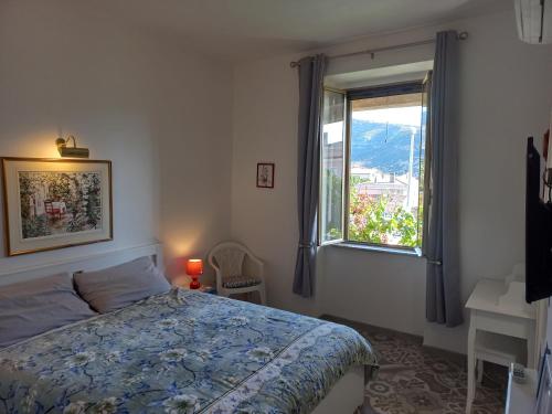 um quarto com uma cama e uma janela em The Englishmans Home em Cuglieri