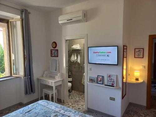 a bedroom with a bed and a sink and a tv at The Englishmans Home in Cuglieri