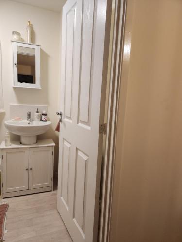 a bathroom with a white door and a sink at Rehoboth in Yew Gardens in Doncaster