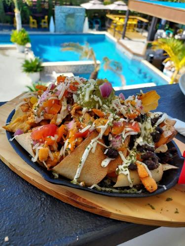 a plate of food on a table next to a pool at Aqua Marina Beach Club in Rincon