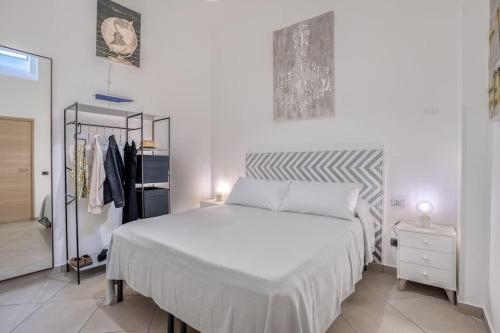 ein Schlafzimmer mit einem großen weißen Bett und einem Schrank in der Unterkunft Two Bedrooms Apt in Sorrento Center with Terrace in Sorrent