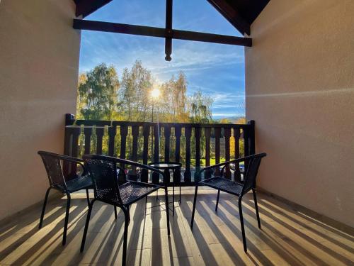 uma varanda com 2 cadeiras, uma mesa e uma grande janela em Angelika 9A/3 Mountain Aparts em Świeradów-Zdrój