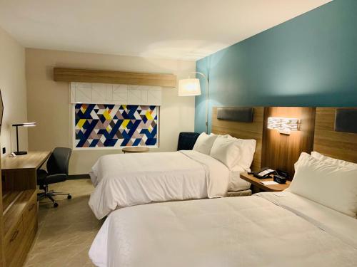グアダラハラにあるHoliday Inn Express - Guadalajara Vallarta Poniente, an IHG Hotelのベッド2台とデスクが備わるホテルルームです。