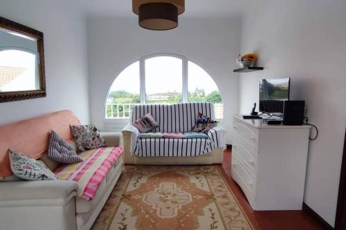 a living room with a couch and a tv at Casa Da Torre in Ribeira Grande