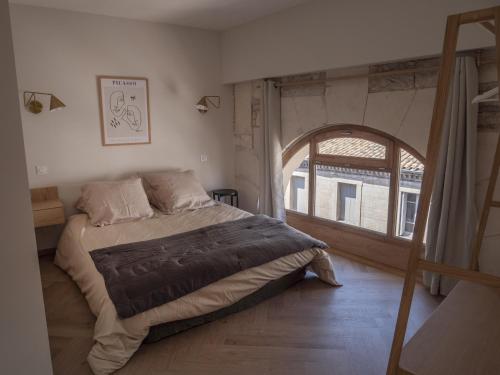 een slaapkamer met een groot bed en een boog bij LE NID BLEU Duplex en plein centre in Castres