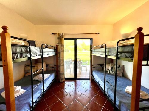 a room with three bunk beds and a patio at Alvor Secret With Pool by Homing in Alvor
