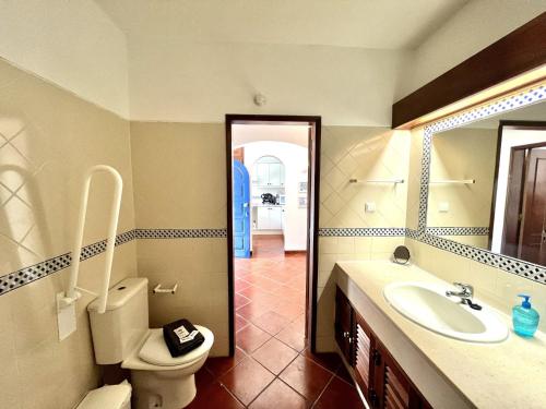 a bathroom with a toilet and a sink and a mirror at Alvor Secret With Pool by Homing in Alvor
