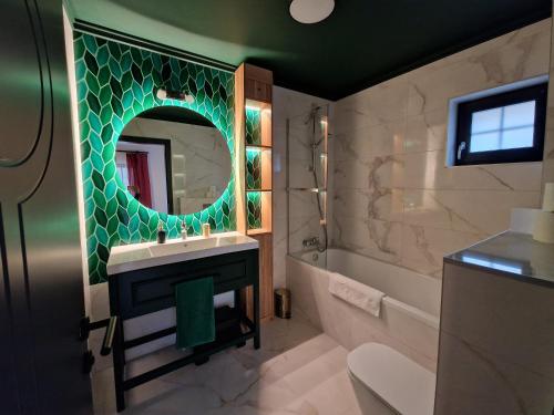 uma casa de banho com um lavatório, um espelho e uma banheira em Edit Villa Friends em Matrafured