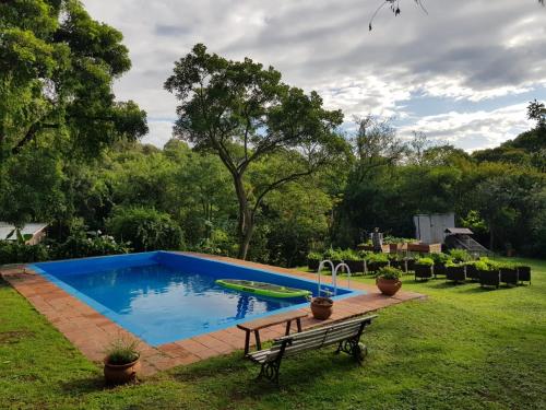 una piscina en un patio con un banco en Cabaña Cultura Río en San Lorenzo
