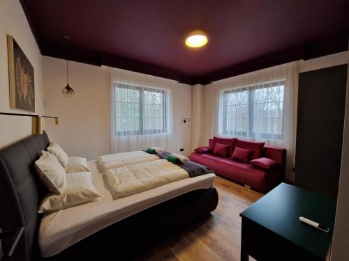 sala de estar con cama y sofá rojo en Edit Villa Friends, en Mátrafüred
