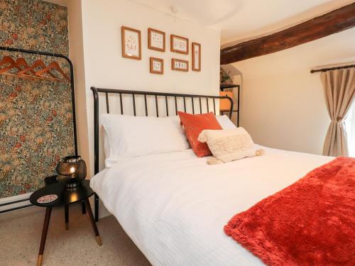 a bedroom with a large white bed with red pillows at Tilly's Place in Heysham