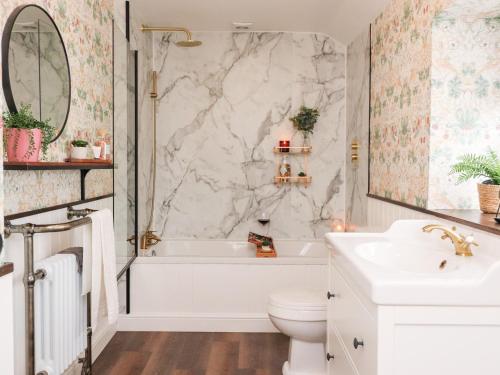 a bathroom with a tub and a toilet and a sink at Tilly's Place in Heysham