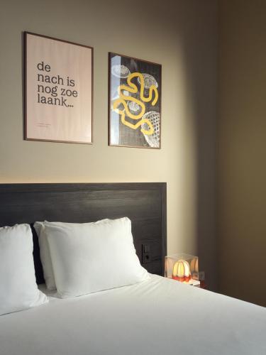 a bedroom with a bed with two pictures on the wall at Townhouse Maastricht & Spa in Maastricht