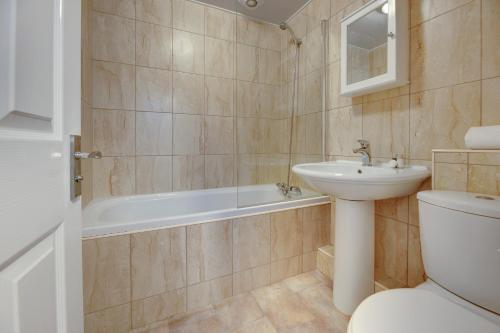 een badkamer met een wastafel, een toilet en een bad bij Armstrong Apartments by Week2Week in Newcastle upon Tyne