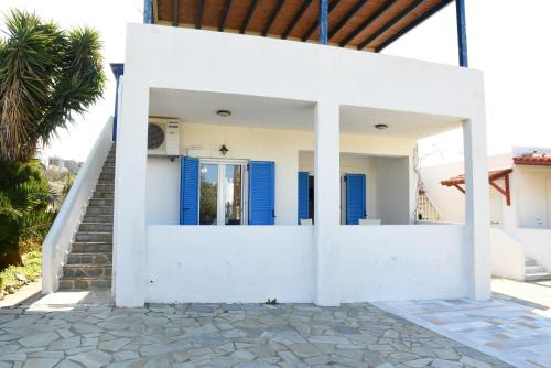 a white house with blue doors and stairs at Andros 2 berdrooms 4 persons cycladic house. in Kypri