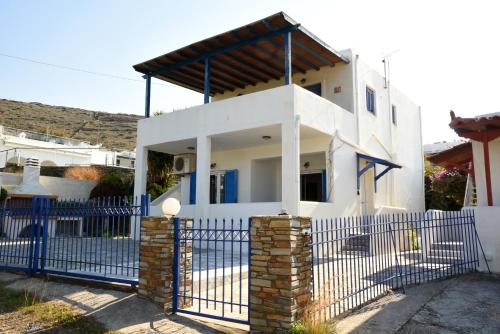 a white house with a blue fence at Andros 2 berdrooms 4 persons cycladic house. in Kypri