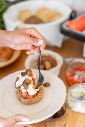 a person holding a fork over a piece of food on a plate at Blue Horizon in Palaiochóra