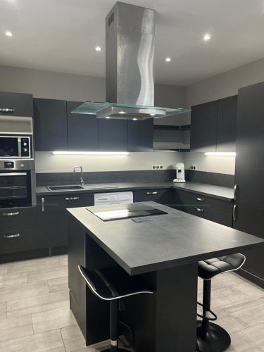 a kitchen with black cabinets and a black counter top at Logement privé à proximité du Mont Ventoux in Carpentras