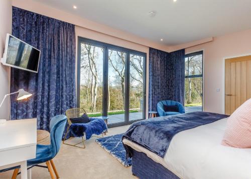 a bedroom with a bed and a large window at Swanborough Lakes in Lewes
