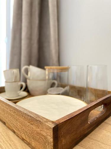 - un plateau en bois avec de la vaisselle et des tasses sur une table dans l'établissement PALACE ROOM CROISETTE, à Cannes