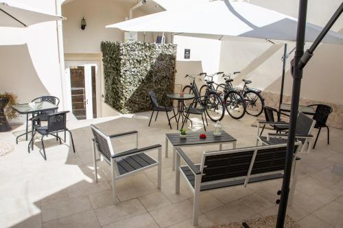 een patio met tafels, stoelen en fietsen bij Dimora Guerrieri in Brindisi
