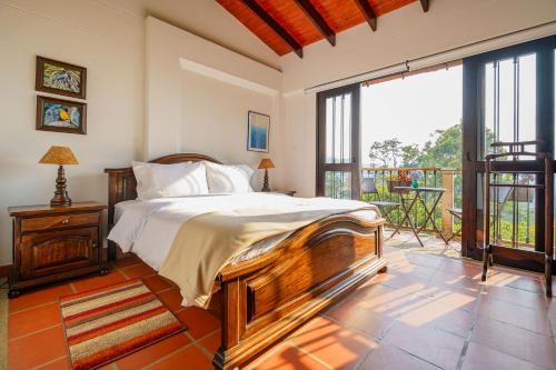 a bedroom with a bed and a balcony at Acaima Café Lodge in Sasaima